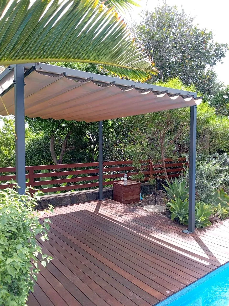 Pergola bioclimatique aluminium au bord d'une piscine