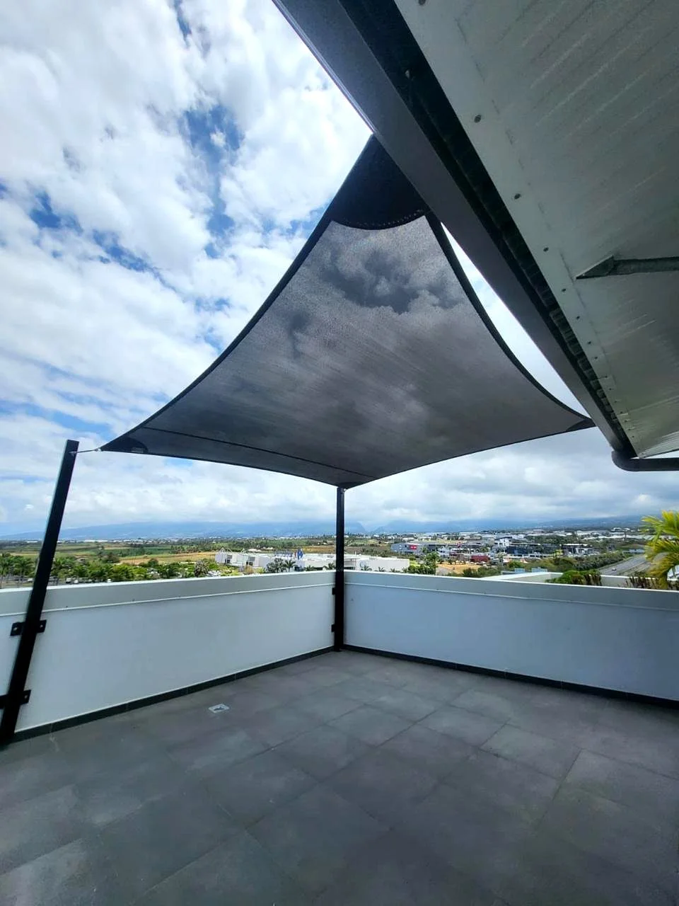 Voile d'ombrage sur terrasse urbaine avec vue sur ville en Loire-Atlantique